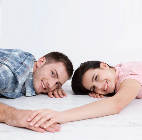 幸福的年轻夫妇 躺在地板上 互相看着对方 梦想着家具为新公寓 模拟设计 免版税图库照片