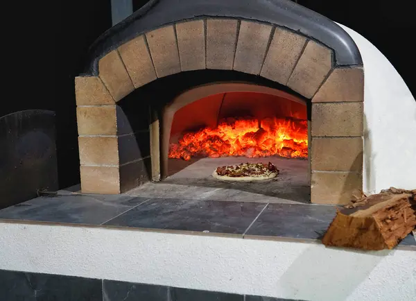 石制比萨饼烤箱加热并烹调一个比萨饼 — 图库照片#