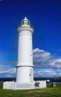 El değmemiş beyaz deniz feneri, Kiama NSW Avustralya 'da canlı mavi gökyüzünün arka planına karşı dimdik ayakta duruyor.