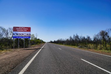 Tropikal Kuzey Queensland için canlı bir hoş geldin işareti. Mavi gökyüzüne ve açık araziye karşı kurulmuş ziyaretçileri karşılıyor..