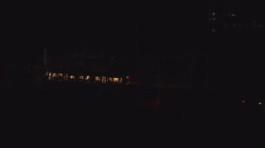 The approach of the tram to the stop and the exit of passengers in complete darkness