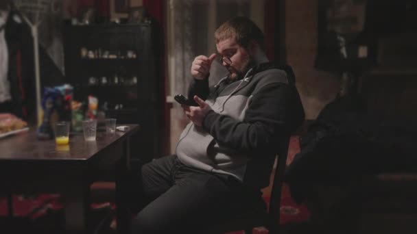 Big Guy Looks News Smartphone Room Dull Interior Sways His — Vídeos de Stock