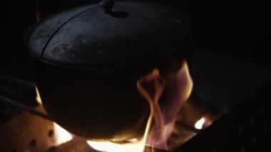 Slow motion video of a burning campfire with a cauldron standing on it