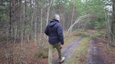 A man establishes the reasons for the fall of trees on the road, blocking the passage