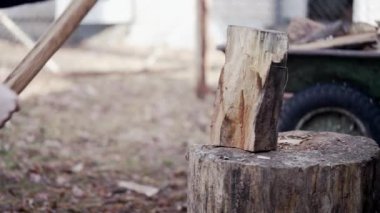 Part of the log is chopped into small chips and scatters in different directions from the blow of the cleaver