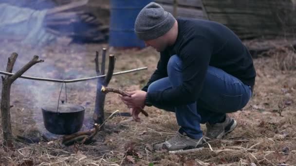 Young Man Inspects Campfire Does Out Can Cook His Own — Stock video