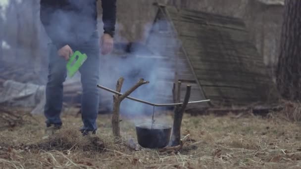 Young Man Fanning Smoking Fire Cauldron Hanging Plastic Spatula — 图库视频影像