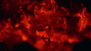 Close-up texture of burning, charcoal slowly smoldering in a stove.