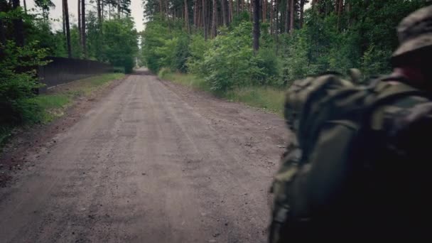 Солдат Проходить Повз Камеру Зупиняючись Щоб Оглянути Дорогу — стокове відео