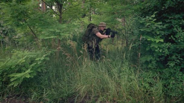 Een Soldaat Komt Uit Het Bos Weg Onderzoekt Dichte Vegetatie — Stockvideo