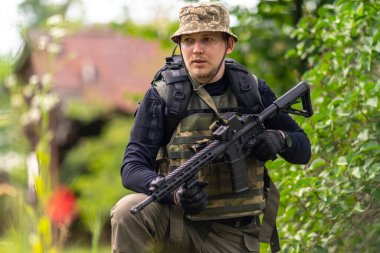 Askeri üniformalı genç bir adam etrafa bakıyor.