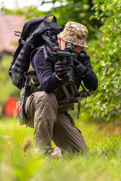 Askeri Üniformalı Genç Bir Adam Otururken Tüfeğinin Dürbününe Bakar — Stok fotoğraf