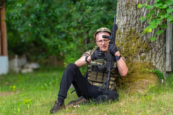 Man Military Uniform Sitting Tree Loads Rifle — Stock Photo, Image