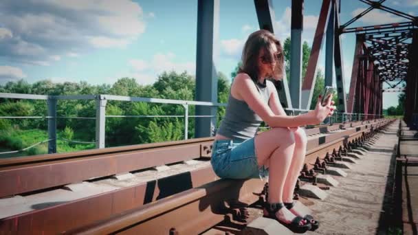 Holka Sedí Kolejích Projíždí Přes Most Snaží Udělat Selfie — Stock video