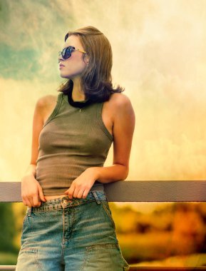 Köprüde sırtı arka planda duran ve dirsekleriyle korkuluklara yaslanan bir kızın stilize edilmiş görüntüsü.