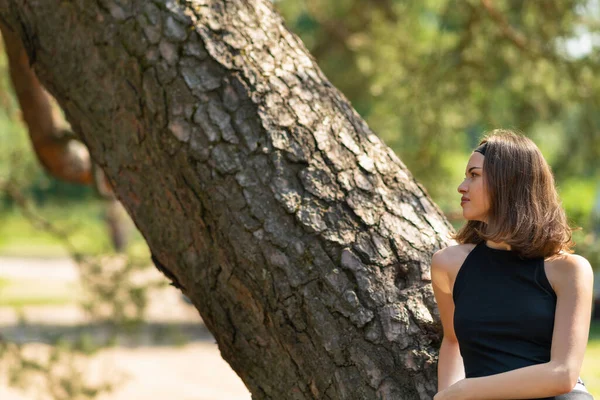 Молода Жінка Біля Дерева Дивиться Геть Насолоджуючись Природою Стокова Картинка