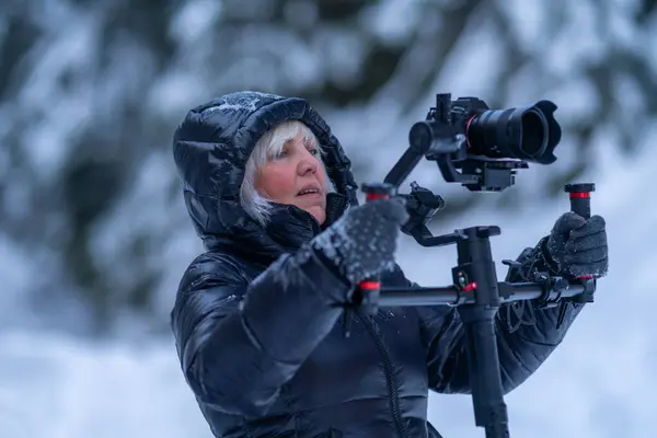 Kvinna Vinterjacka Håller Kamera Med Stabilisator Med Ett Tvåhandsgrepp — Stockfoto