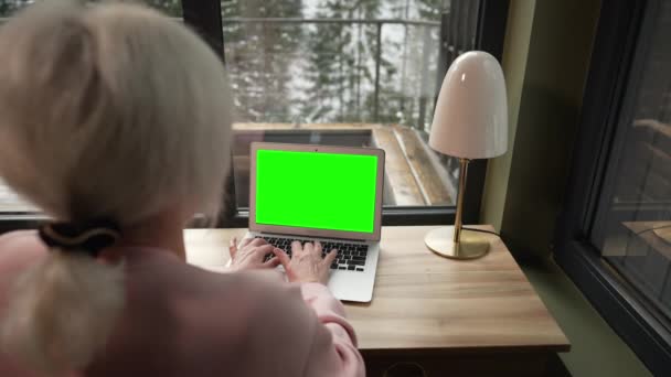 Жінка Друкує Щось Ноутбуці Зеленим Екраном Тлі Снігу Падає Вікном — стокове відео