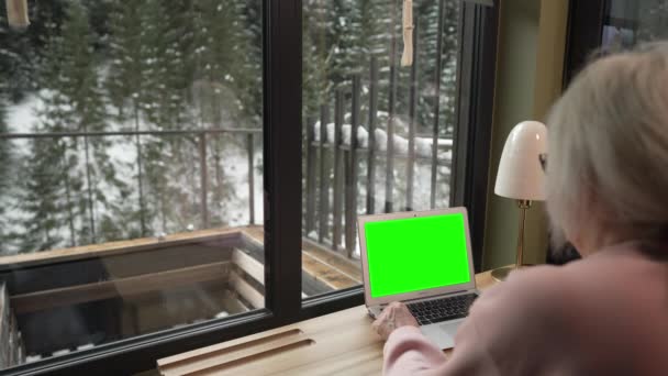 Laptop Zielonym Ekranem Kobieta Średnim Wieku Siedzi Przed Nim Podczas — Wideo stockowe