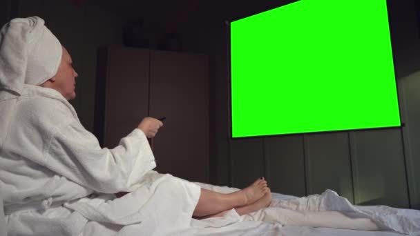 Yeşil Ekran Projeksiyon Öndeki Yatakta Oturan Terry Bornozlu Bir Kadın — Stok video