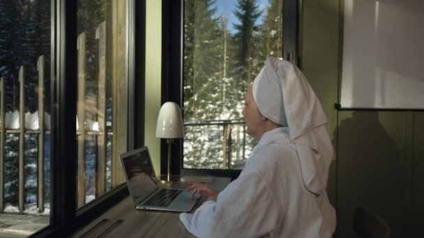 Dorosła Kobieta Szlafroku Zakrywająca Włosy Ręcznikiem Używa Laptopa Siedząc Przy — Wideo stockowe