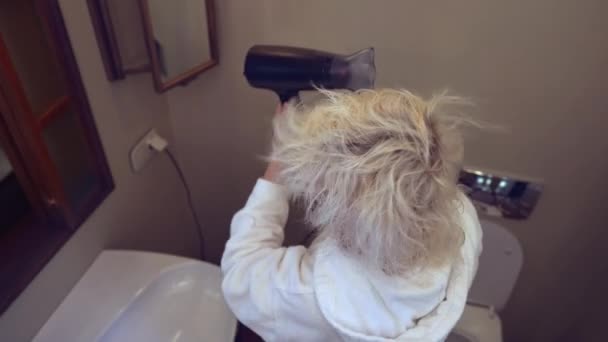 Widok Kobiety Szlafroku Pomocą Suszarki Włosów Stojąc Przed Oknem Łazience — Wideo stockowe