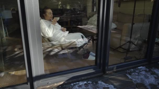 Terry Bornozlu Yaşlı Bir Kadın Oturma Odasında Çay Içiyor Pencerenin — Stok video