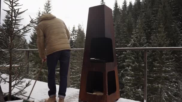 Man Sopar Snö Från Trägolvet Terrassen Sitt Bergshem — Stockvideo