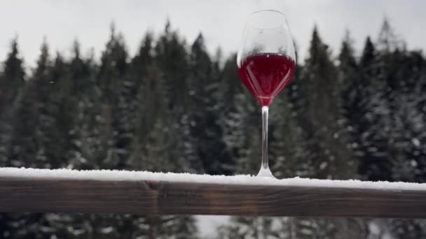 Glass Red Wine Railing Backdrop Winter Forest Flying Snowflakes — Stock Video