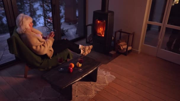 Zimowy Wieczór Kobieta Dzianinach Siedzi Przed Kominkiem Płonącym Drewnem Salonie — Wideo stockowe