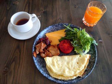 Avrupa usulü omlet, domates ve kızarmış tavuk parçaları ile kahvaltı.