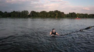 Bir sporcu kadın, bir su kaydıyla nehirde yüzer..