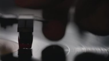 Kaydın sonuna ulaşan plaktan bir iğneyle kafasını koparan bir adamın yakın çekimi..