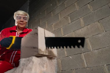 Gazlı beton testereyle beton bloklar kesen kadına odaklan..