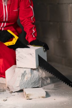 Testerenin altından uçan tuğla parçaları iş sırasında köpük beton kesiyor..