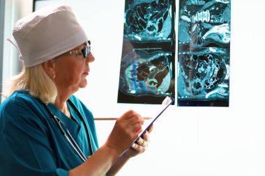 Kadın bir doktor, hastanın tıbbi test sonuçlarını takip etmekten sorumludur..