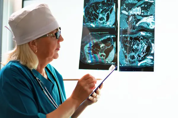 Kadın bir doktor, hastanın tıbbi test sonuçlarını takip etmekten sorumludur..