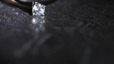 Siyah bir taş yüzeyde elmas bir yüzük var..