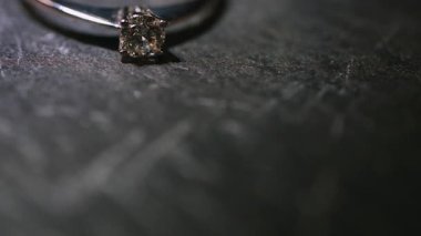 Taş bir masanın üzerinde duran elmas yüzüğün değişken ışıklandırması.