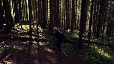 Dişi bir dağcı, bulunan bir dalı kullanarak bir dağ yoluna tırmanır..