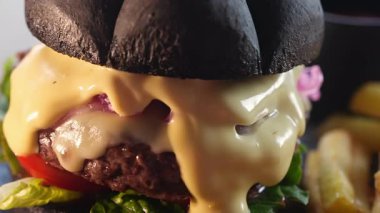 Köfteli hamburger, peynir, siyah ekmekli mavi soğan ve patates kızartması..