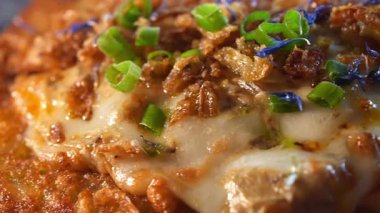 Erimiş peynir ve çiçek yapraklarıyla tatlandırılmış yeşil soğanlı patatesli gözleme..