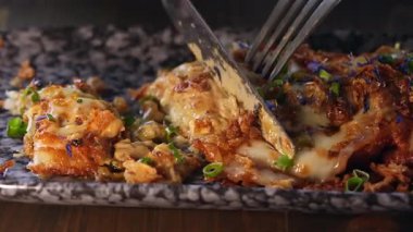 Bir insan patates gözlemesinin bir kısmını kesmek için çatal ve bıçak kullanır..