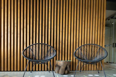 Bir kaplıcada yan yana duran iki sandalye, tahta levhalara karşı..