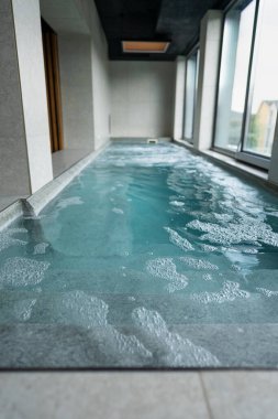 Bir spa salonunda su masajı için kullanılabilecek yüksek basınçlı jetleri olan bir havuz bulunur..