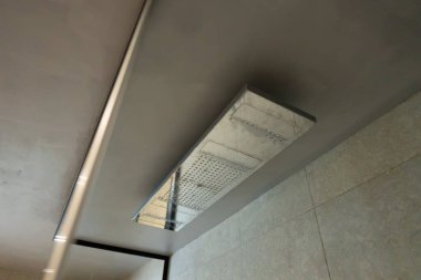 Duş paneli tavandan sarkıtılmış durumda. Dahili başlıklardan çok amaçlı su tedarik ediliyor..