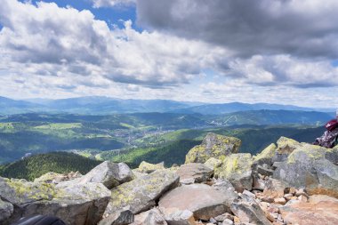 Aşağıdaki vadiyi ve birinin tepesinden etrafındaki dağları gör..