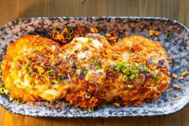 Yeşil soğan ve peynir tabakta patatesli gözlemelerin üzerine saçıldı..