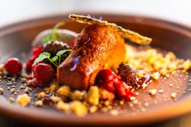 Ahududu, çilek, bal, krem şanti ve nane yaprakları ballı sünger kekiyle süslenir..