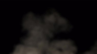 Siyah bir arkaplan karşısında, duman görünür bir şekilde sönmüş ve aşağıdan yükseliyor..